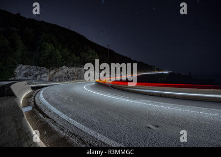 Coches circulando de noche por la carretera de curvas en Cataluña Banque D'Images