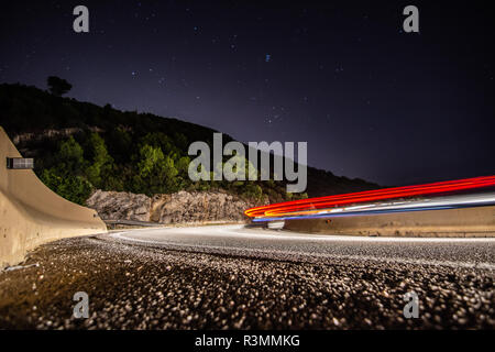 Coches circulando de noche por la carretera de curvas en Cataluña Banque D'Images