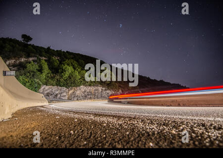 Coches circulando de noche por la carretera de curvas en Cataluña Banque D'Images