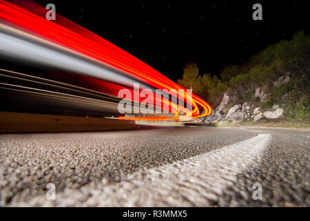 Coches circulando de noche por la carretera de curvas en Cataluña Banque D'Images