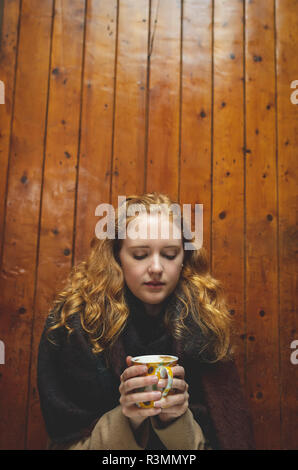 Femme tenant une tasse de café en café Banque D'Images