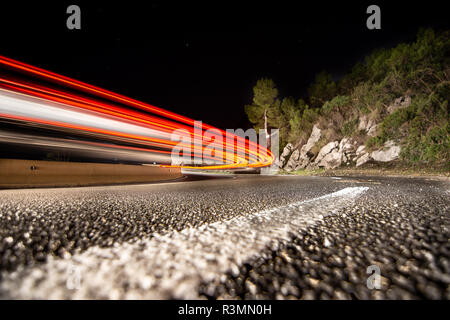 Coches circulando de noche por la carretera de curvas en Cataluña Banque D'Images