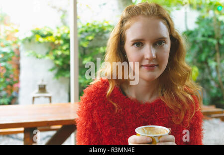 Femme tenant une tasse de café dans le café en plein air Banque D'Images