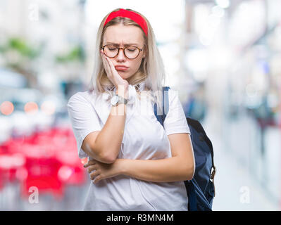 Jeune étudiante blonde femme portant des lunettes et sac à dos sur fond isolé à la pensée fatigué et ennuyé par la dépression Les problèmes avec crosse Banque D'Images