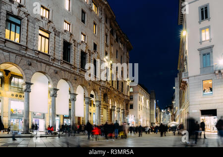 Une longue exposition de shoppers noël à Corso Vittorio Emanuele II près de Duomo à Milan, Lombardie, Italie par une froide nuit de novembre. Banque D'Images