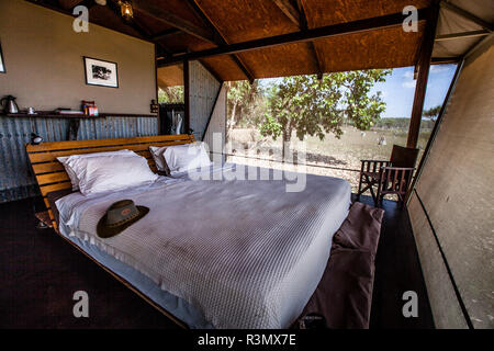 Lit double dans l'Outback australien chic derrière les murs en fer ondulé du Bamiburru Plains Lodge.Le vent souffle à travers les écrans de vol et personne ne manque la climatisation ou le Wi-Fi.Territoire du Nord, Australie territoire du Nord, Australie Banque D'Images