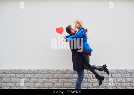 Un couple d'amoureux dans un manteau avec des coeurs dans les mains. Banque D'Images