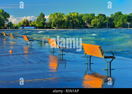 Le Canada, l'Ontario, St. Des bancs sur le quai au lever du soleil sur le lac Ontario. Banque D'Images