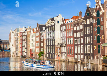 Maisons sur le Damrak Amsterdam maisons avec l'architecture néerlandaise par le canal Le canal bateau croisière à quitter le Damrak Amsterdam Hollande Pays-bas eu Europe Banque D'Images