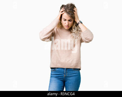 Très belle jeune femme blonde portant des sweatershirt sur fond isolé avec la main sur la tête pour la douleur dans la tête parce que le stress. Souffrant de migraines. Banque D'Images