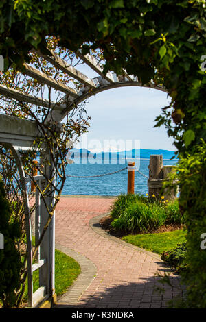 Sidney, île de Vancouver, Colombie-Britannique, Canada, Garden trellis archway et brique chemin mène à la Puget Sound & Mont Baker Banque D'Images