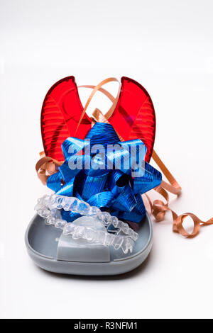 Dents transparent isolés d'alignement de la prothèse avec son fort et blue bow un moyen d'avoir un beau sourire, don Banque D'Images