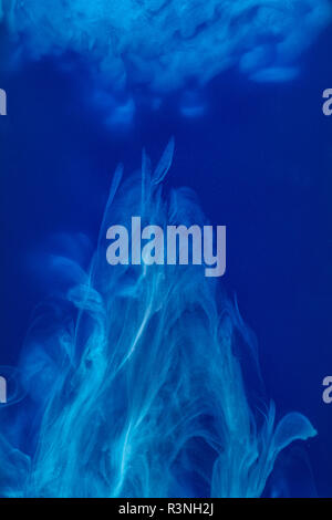 Abstract pattern de tomber dans l'eau goutte d'encre bleu encre cyan - dissous dans l'eau sur bleu Banque D'Images