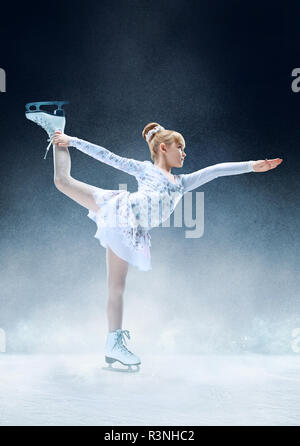 Petite fille au patinage artistique patinoire intérieure. La danse, sport d'hiver, l'exercice, de la formation, de l'enfance, champion concept Banque D'Images