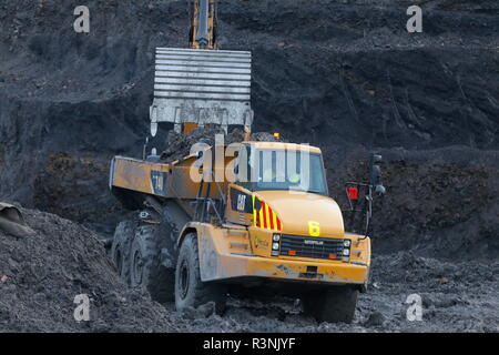 Une chenille 349E chargement de camions à benne sur le Recycoal,usine de recyclage de charbon à Rossington,Doncaster. qui a été démoli. Banque D'Images