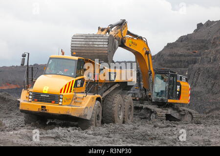 Une chenille 349E chargement de camions à benne sur le Recycoal,usine de recyclage de charbon à Rossington,Doncaster. qui a été démoli. Banque D'Images