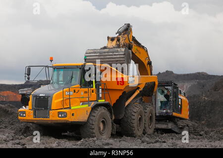 Une chenille 349E chargement de camions à benne sur le Recycoal,usine de recyclage de charbon à Rossington,Doncaster. qui a été démoli. Banque D'Images