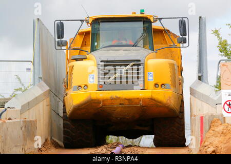 Un tombereau articulé tire à travers ce pont étroit à travers un chemin de fer sur la construction d'IPORT à Rossington, Doncaster, South Yorkshire Banque D'Images