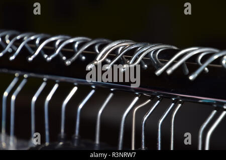 Cintres en plastique détail regardez, cintres en métal sur un plan macro rail vêtements Banque D'Images