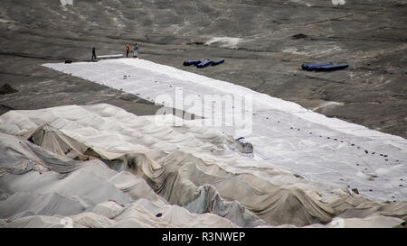 Climat | Albedo | Rhône : d'énormes couvertures en polaire couvrent des parties du glacier du Rhône en Suisse pour tenter de bloquer l'inévitable fonte de la neige et de la glace. Après un hiver avec des quantités record de neige, la plupart de cette photo a disparu lorsque cette photo a été prise le 14 juillet 2018, exposant la glace plus sombre. Alors que la neige est un brillant réflecteur de l'énergie du soleil, la glace plus sombre absorbe l'énergie, accélérant ainsi la fonte du glacier. La couleur et l'obscurité de la glace du glacier varient partout dans le monde, selon l'accumulation de pollution, l'âge de la glace, les particules captées par la glace et par le micro Banque D'Images