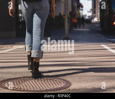 Femme marche dans la ville sur une journée ensoleillée Banque D'Images