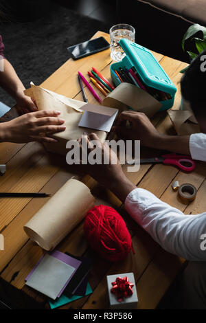 Emballage boîte-cadeau couple dans la salle de séjour Banque D'Images