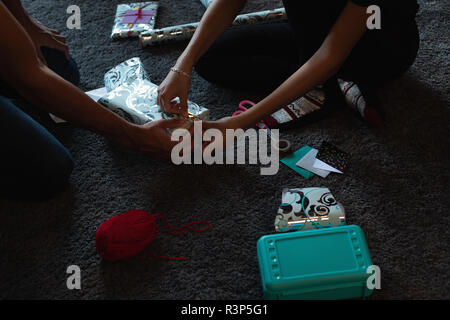 Emballage boîte-cadeau couple sur le plancher à la maison Banque D'Images