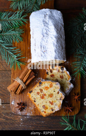 Gâteau de pain aux fruits saupoudrés de sucre glace, de Noël et vacances d'hiver traiter, des gâteaux de raisins secs sur fond de bois Banque D'Images