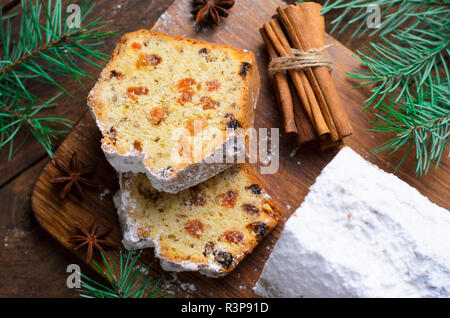 Gâteau de pain aux fruits saupoudrés de sucre glace, de Noël et vacances d'hiver traiter, des gâteaux de raisins secs sur fond de bois Banque D'Images