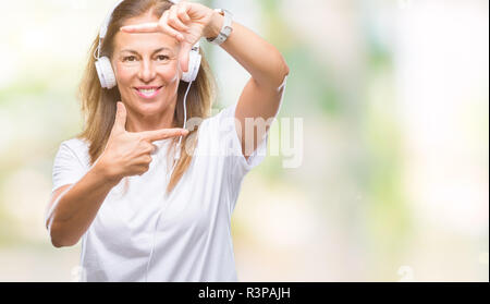 L'âge moyen hispanic woman wearing headphones sur fond isolé du châssis en souriant avec les mains et les doigts avec un visage heureux. Banque D'Images