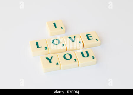 Jeu de Scrabble lettres avec valeur score formant la phrase 'J'aime' sur fond blanc. Banque D'Images