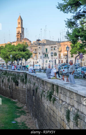 Des gens assis sur le mur de château Svevo, Vieille Ville, Bari, Italie Banque D'Images