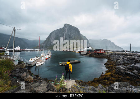 La Norvège, les îles Lofoten, vue arrière de l'homme debout à la côte Banque D'Images