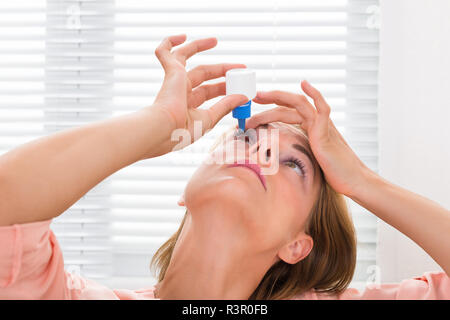 Woman Pouring Médicament gouttes dans les yeux Banque D'Images