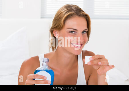 Femme tenant une bouteille de rince-bouche Banque D'Images