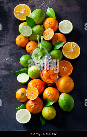 Limes, citrons, oranges et mandarines om fond sombre Banque D'Images