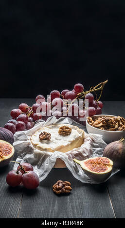 Concept d'apéritifs pour le vin, fromage Camembert, raisins noirs, les noix et les figues avec du miel, sur un fond rustique en bois, un espace réservé au texte Banque D'Images