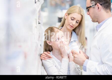 Pharmacien montrant la médecine pour fille et femme malade en pharmacie. Banque D'Images