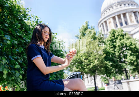 UK, Londres, jeune femme en utilisant sa smartwatch près de la Cathédrale St Paul Banque D'Images