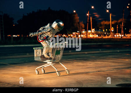 Spaceman dans la ville la nuit sur parking à l'intérieur panier Banque D'Images