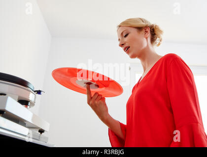 Young woman holding red vinyl record Banque D'Images