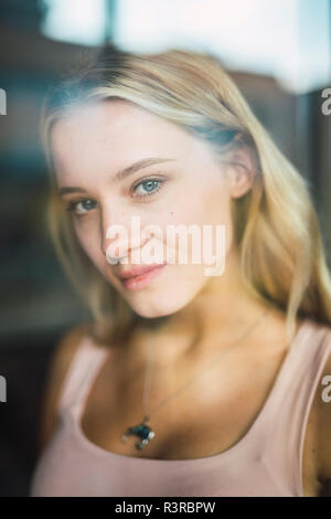 Portrait de jeune femme derrière la vitre Banque D'Images