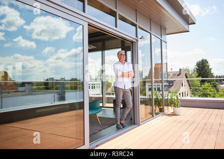 Man relaxing debout à toit-terrasse à la maison Banque D'Images