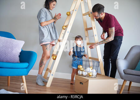 La famille moderne de décoration de la maison au moment de Noël, à l'aide d'échelle comme arbre de Noël Banque D'Images