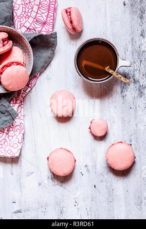 Macarons rose rempli de buttercream framboise et une tasse de café Banque D'Images