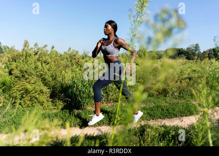 Jeune athlète courir dans les champs Banque D'Images