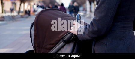 Coup de frais généraux de jeune mère se promener un chariot. Mains tenant la poignée de la poussette. Banque D'Images