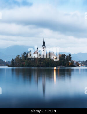 Soir de l'automne le lac de Bled dans les Alpes Juliennes, en Slovénie. Église de pèlerinage de l'assomption de Marie sur un premier plan. Photographie de paysage Banque D'Images