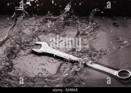 Clés plates de tailles différentes sur un fond sombre dans un jet d'eau. Banque D'Images