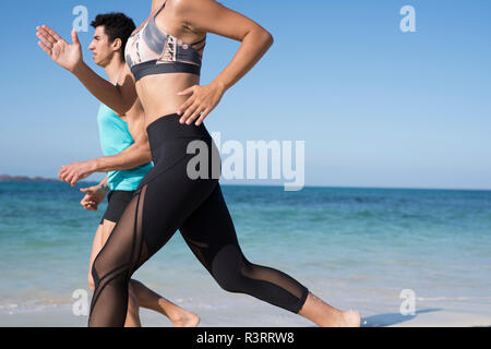 Espagne, Canaries, Fuerteventura, jeune couple d'exécution sur la plage Banque D'Images